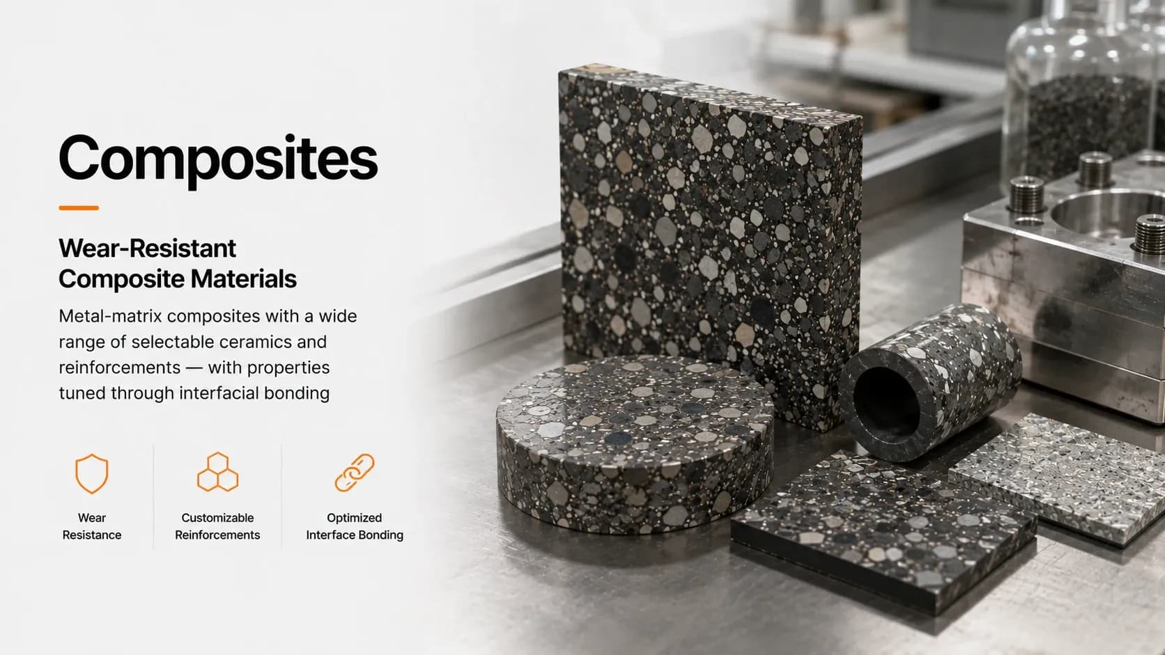 Metal-matrix composite blocks, discs and a sleeve showing coarse ceramic reinforcement particles, on a steel bench beside tooling.