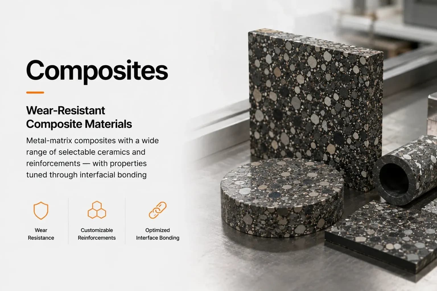 Metal-matrix composite blocks, discs and a sleeve showing coarse ceramic reinforcement particles, on a steel bench beside tooling.